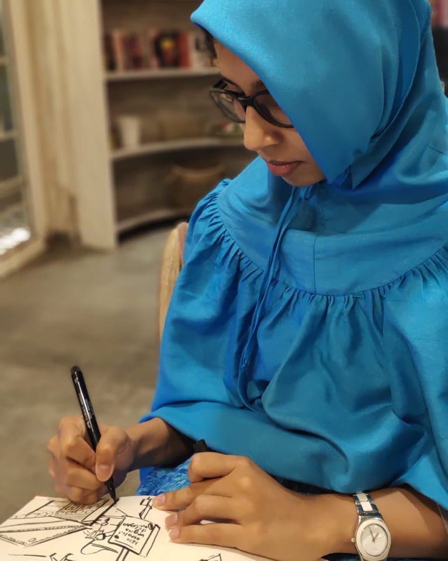Tasneem Amiruddin illustrating at her desk